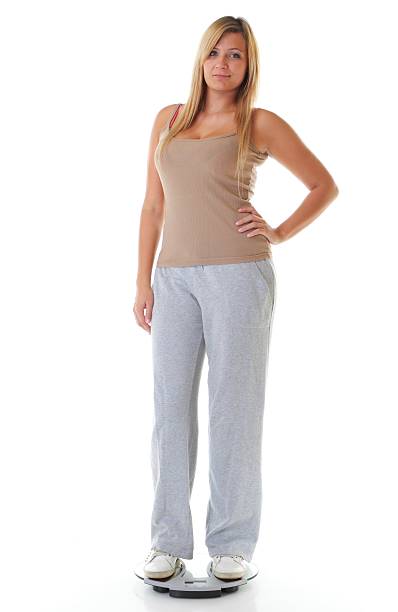 istock Large woman on scale measuring her weight 187354177