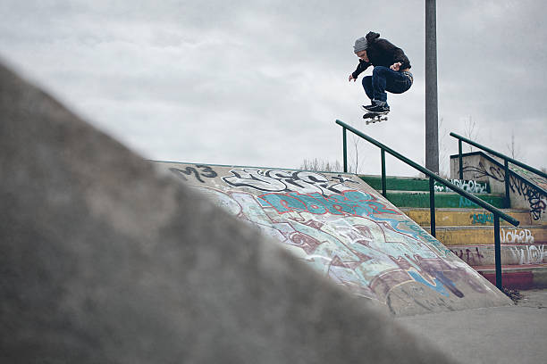 istock Skateboarder doing Ollie over the rail in a skatepark 187354248