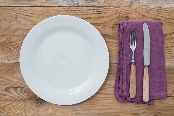 istock White plate and cutlery on wood 187354807