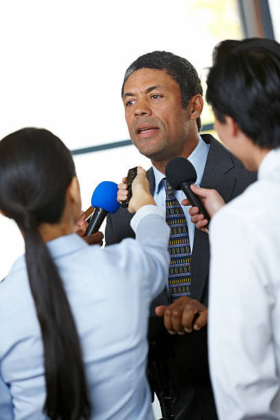 istock Mature male executive being questioned by journalists 187355280
