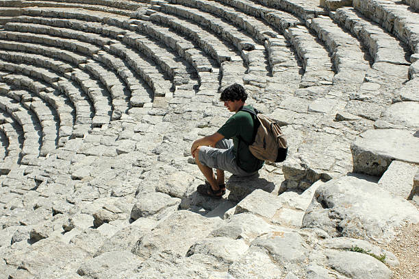 istock tourist sitting in the Segesta Amphitheater 187356462