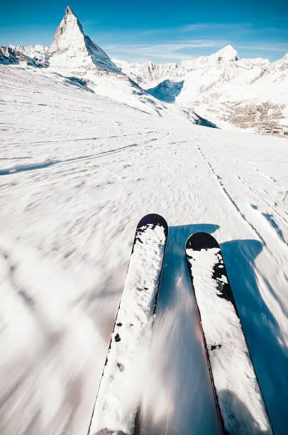 Skiing at speed down a steep piste in the European Alps.