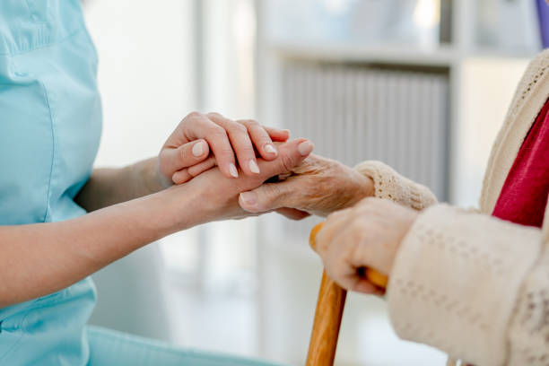 istock Close-Up Of Nurse'S Hand Holding Elderly Woman'S Hand With Cane 1873574075