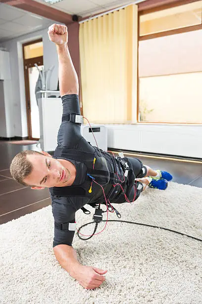 Young adult in a difficult position benefiting from electric muscle stimulation