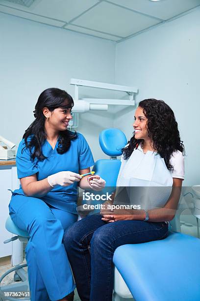 Dentist Teaching Toothbrush Techniques To Young Woman Patient Stock Photo - Download Image Now