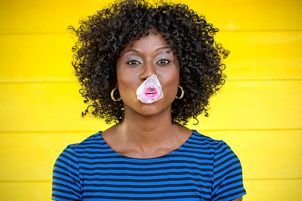 African america woman being silly and playing with bubble gum.