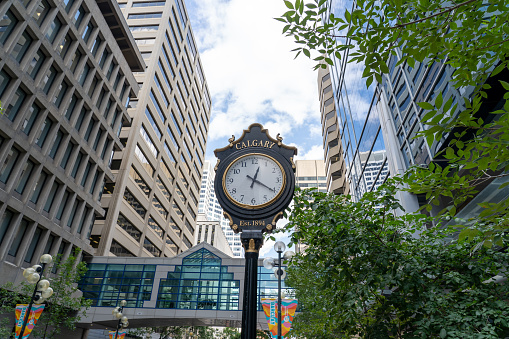 An Old Street Clock from 1894 with buildings in the background in downtown Calgary, Alberta, Canada - July 4, 2023.