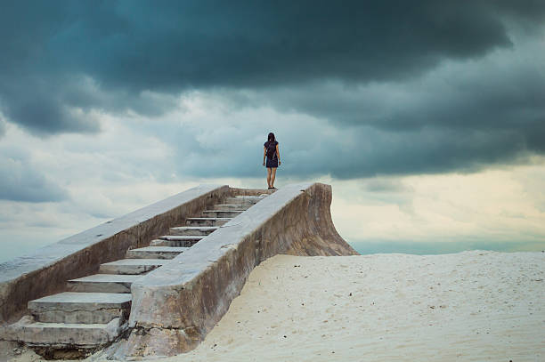 Stairs to nowhere - lonely figure on a beach stock photo