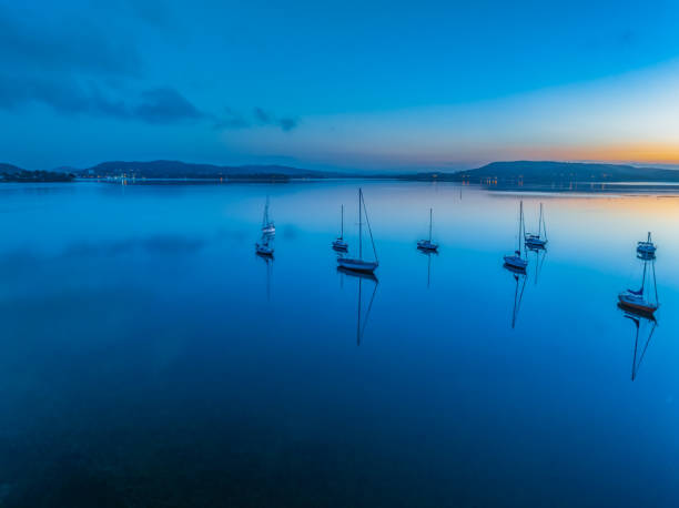 istock Aerial sunrise waterscape with boats, reflections and low cloud 1873668241