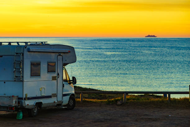 istock Camper vehicle on beach at sunrise 1873695589