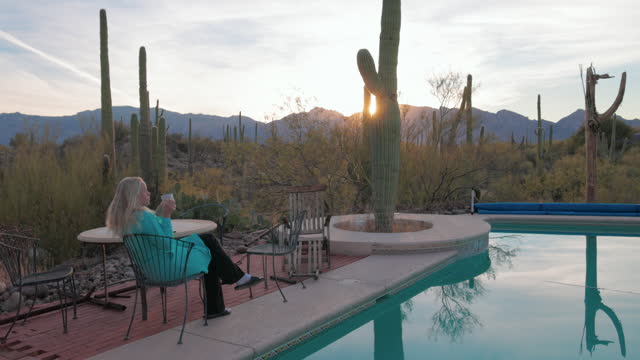 Mature woman enjoys sunrise moments by desertt pool