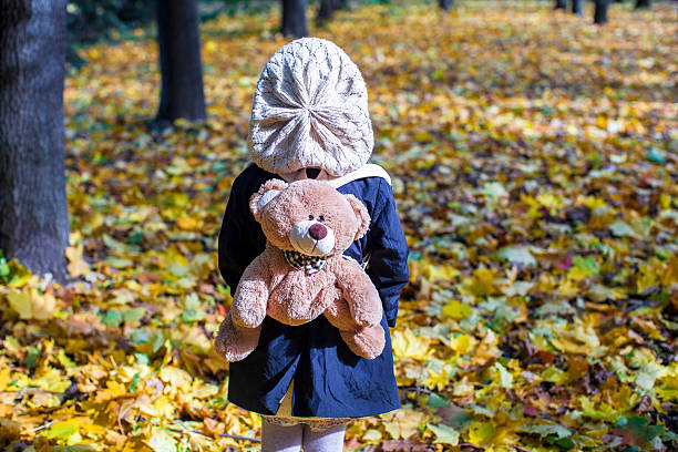 istock Charming girl with backpack-bear behind in the autumn sunny forest 187372470