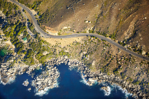 Aerial shot of a road running along the rugged coastline of the western cape