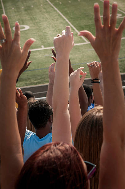 istock Fans with raised arms cheering for their team - V 187376767