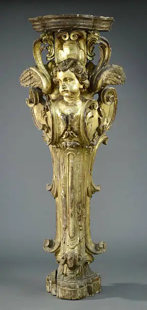French, late 18th/early 19th century, Louis XV carved giltwood figural wall pedestal with cherub bust figurehead over rococo scrolls.  On a gray background.