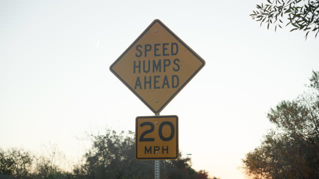 Speed humps bumps ahead street sign to make cars drive slower at 20mph
