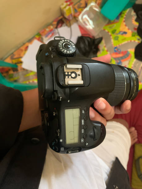 istock hands holding dslr camera with lens, top view 1873795856