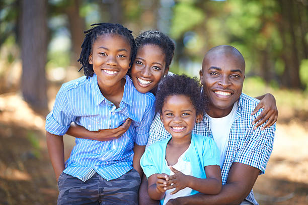 Spending quality family time outdoors Cute african american family spending time out in nature together four people photos stock pictures, royalty-free photos & images