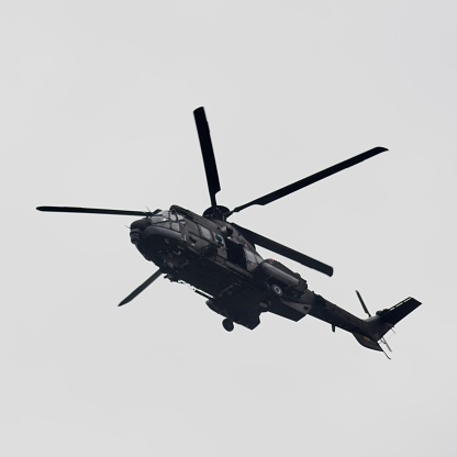 Monochrome image of a helicopter in the air with still blades and crisp details.