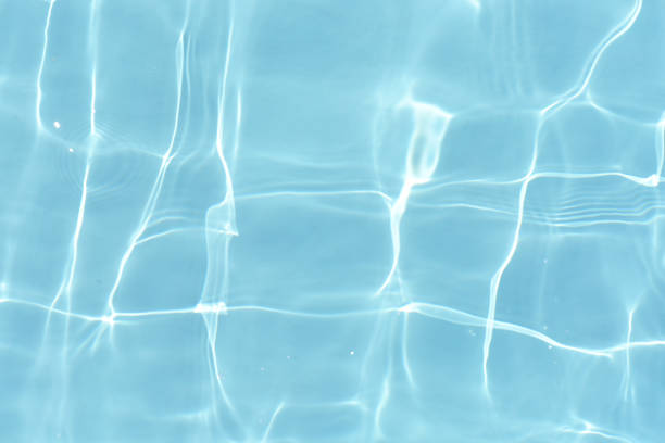 istock Bluewater waves on the surface ripples blurred. Defocus blurred transparent blue colored clear calm water surface texture with splash and bubbles. Water waves with shining pattern texture background. 1873811843
