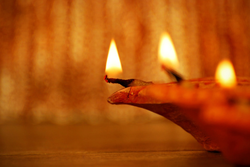 Diyas - Concept of celebration.Focus on thread and wick of left most diya. High depth of field.