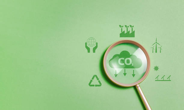istock Magnifying glass with reduce CO2 emissions carbon symbol on green background for climate change to limit global warming and sustainable development and green business concept 1873845607