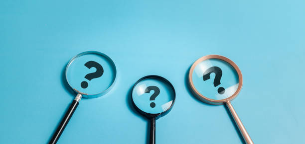 istock Question marks concept. Magnifying glass focuses on question mark symbol for confusion, faq, ask, question or solution. 1873855316