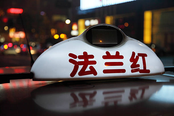Blurred image of a taxi with passengers passing by Hong Kong railroad station. The red taxies are allowed to drive in all districts in Hong Kong, except for Lantau, where only blue taxies are allowed