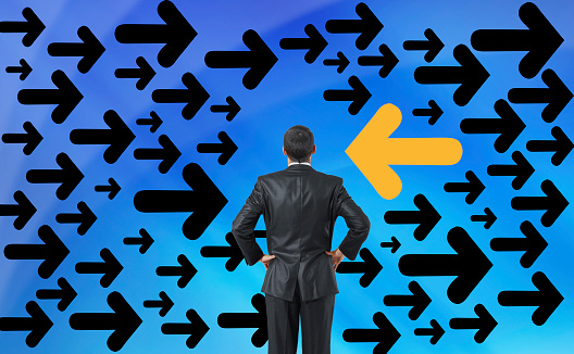 Businessman looking at directional signs and arrows on a digital screen