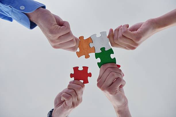 istock Group of business people assembling jigsaw puzzle 187388209