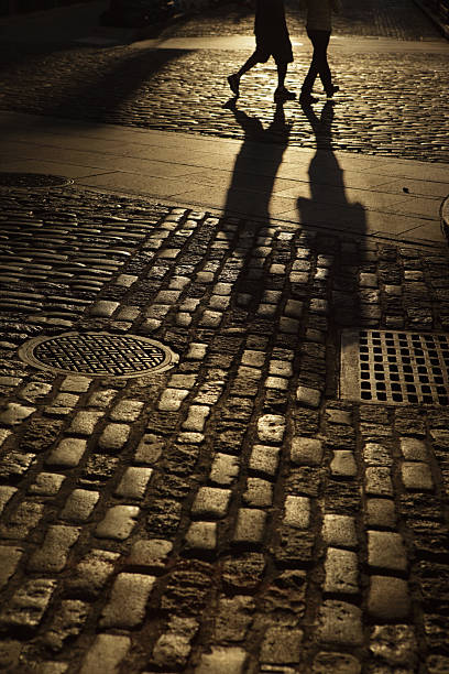 istock Two males walking in amber night shadows 187388456