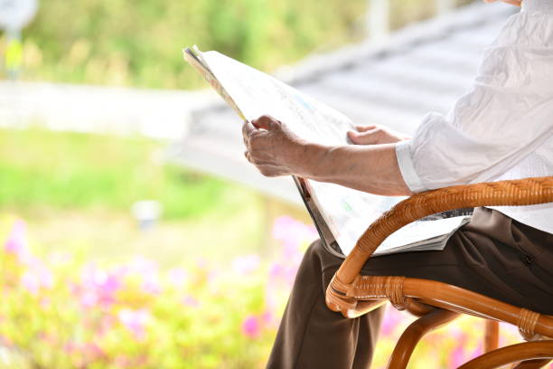 elderly woman reading a newspaper