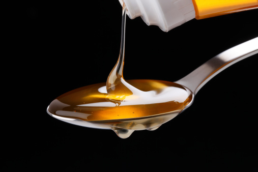 Honey pouring over a spoon on  black background