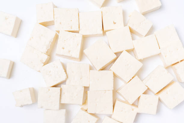 istock Cut tofu cubes on a white background close-up, top view. 1873907588