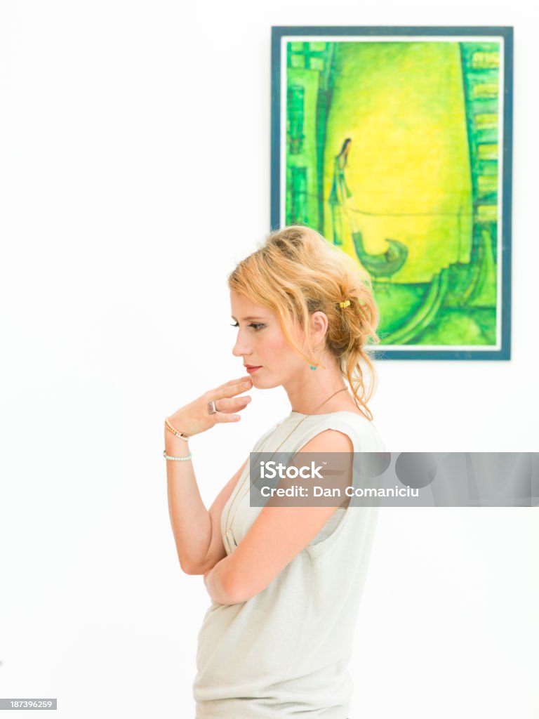 trying to understand the artist's message side view of caucasian woman standing in an art gallery thinking about something Adult Stock Photo