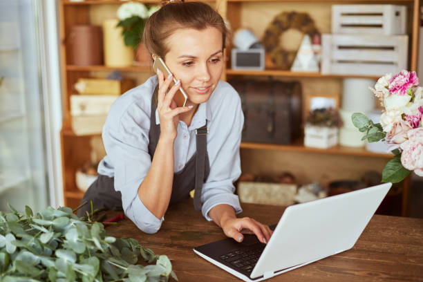 istock Female florist taking delivery order online 1873972924