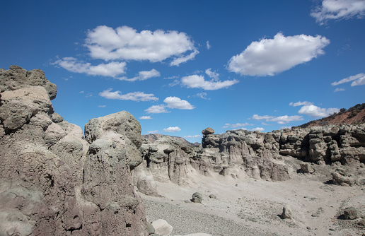 Cloudy blue sky over eroded gray hodo formations in Little Book Cliffs National Monument near Grand Junction Colorado United States