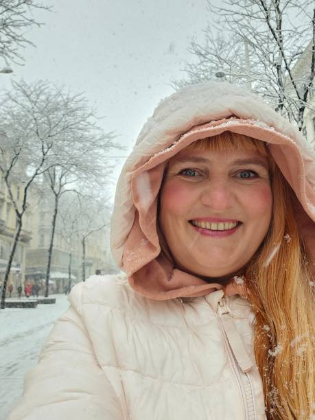 Portrait positive middle-aged woman enjoying snowfall