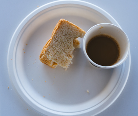 Medium format image of a plate containing the Leftover Sandwich and Unfinished Coffee