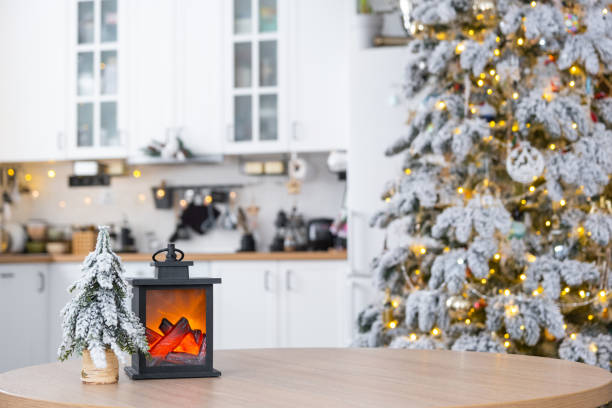 istock Festive Christmas decor on a round empty table with space for text in white kitchen, modern interior with a Christmas tree and fairy lights. New Year, Christmas mood, cozy home. 1874003758