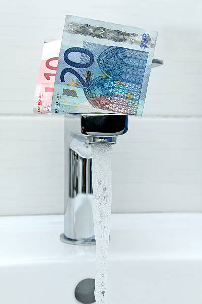 istock money on the tap with flowing water 187401488