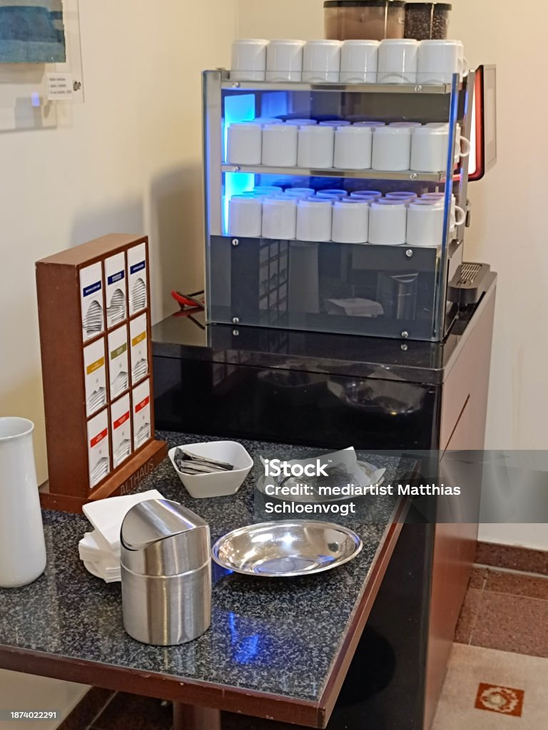 Self-service coffee machine with dishes and tea dispenser in a hotel. Breaks provided with freshly prepared hot drinks Apartment Stock Photo Self-service coffee machine with dishes and tea dispenser in a hotel. Breaks provided with freshly prepared hot drinks Apartment Stock Photo