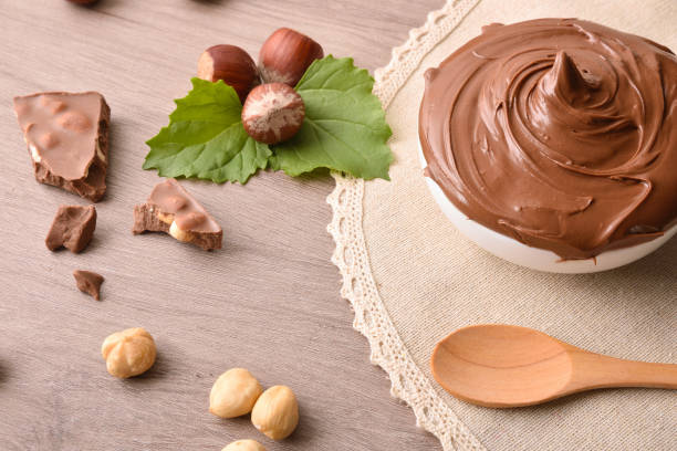 istock Milk chocolate and hazelnut cream on wooden table with tablecloth 1874036461