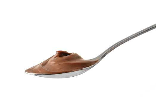 Detail of metal spoon of cocoa cream isolated with white background. Front view.