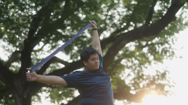 Asian man stretching with a resistance band
