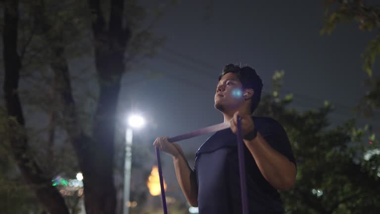 Asian man stretching with a resistance band for biceps