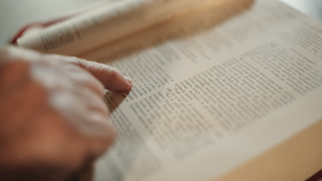 SLO MO High Angle Closeup of Senior Woman Opening and Reading Bible Verse at Table at Home