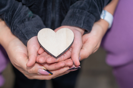 Mother and daughter holding heart Valentine's day. feeling happy together in a spring park.family concept.Closeup.cropped image.