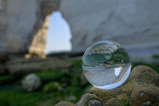 Chalk cliffs of Etretat (Normandy France) seen through glass sphere