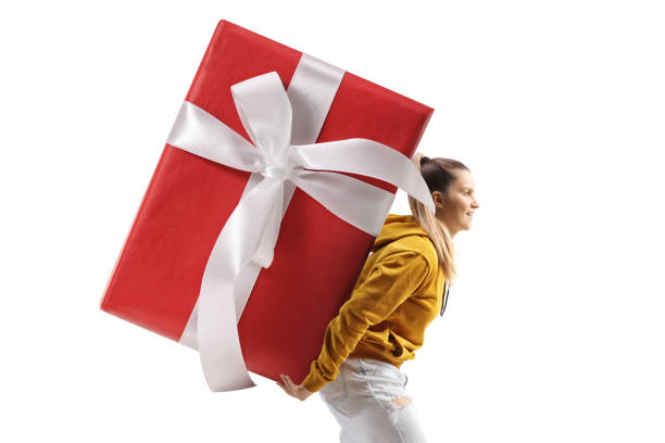 istock Young female carrying a big wrapped present on her back 1874143558